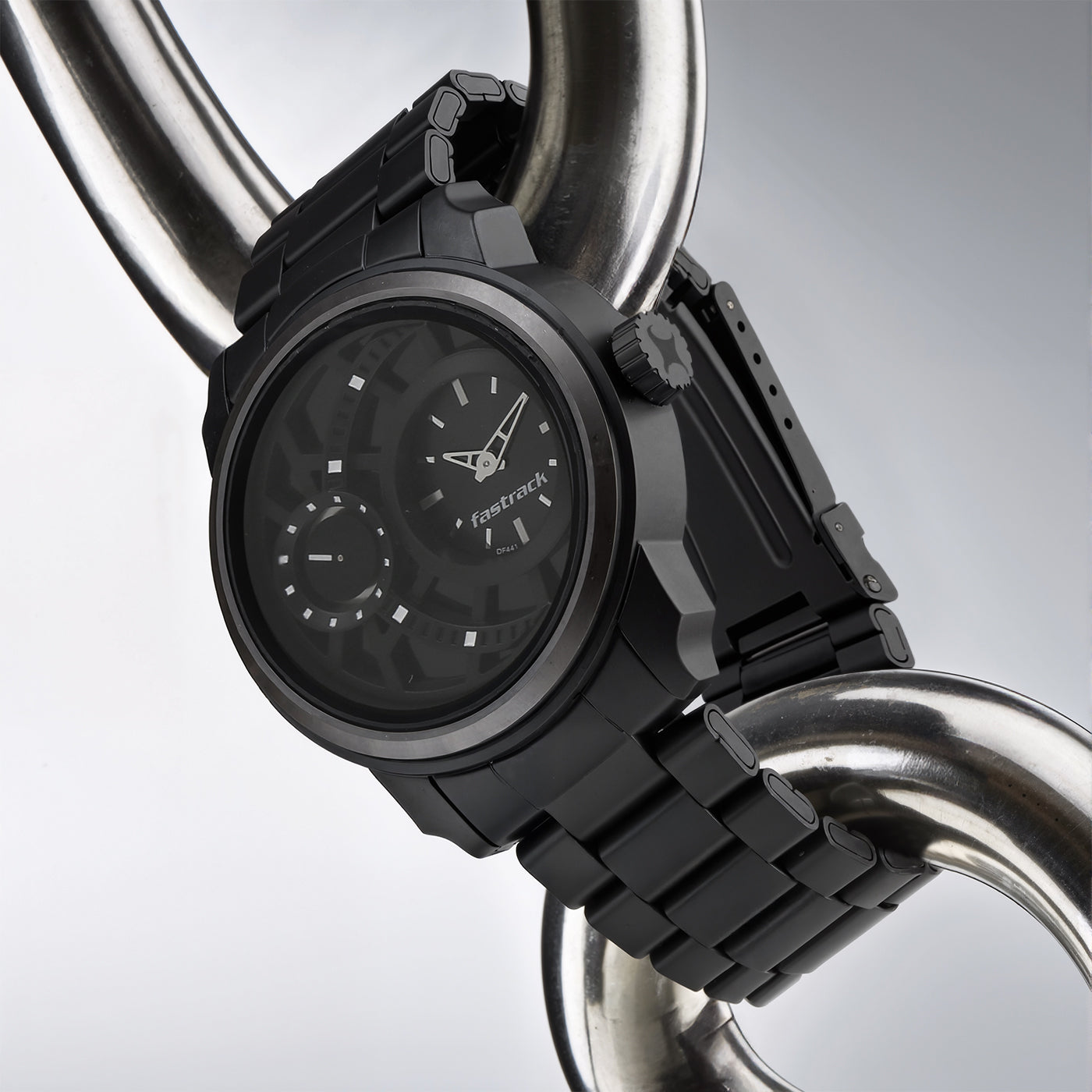 Hanging display of a black dial Fastrack analog watch for men with a rugged metal case and bracelet.