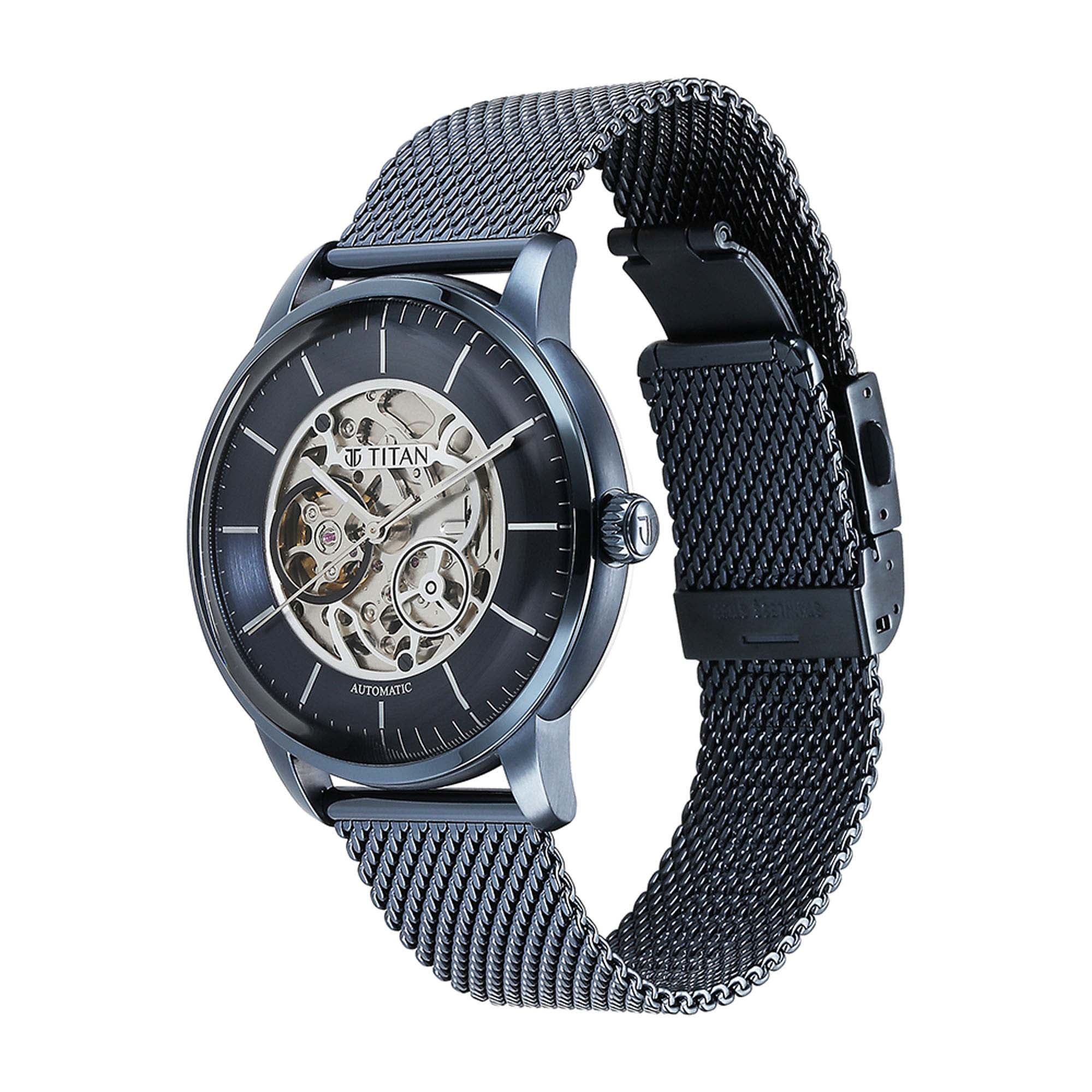 Sleek Titan skeleton analog watch for men with a blue dial & stainless steel strap showing movement.