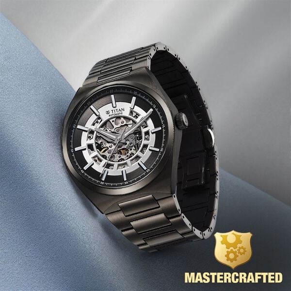 Angled view of Titan Nexus skeletal automatic analog watch for men with gunmetal dial & steel strap.